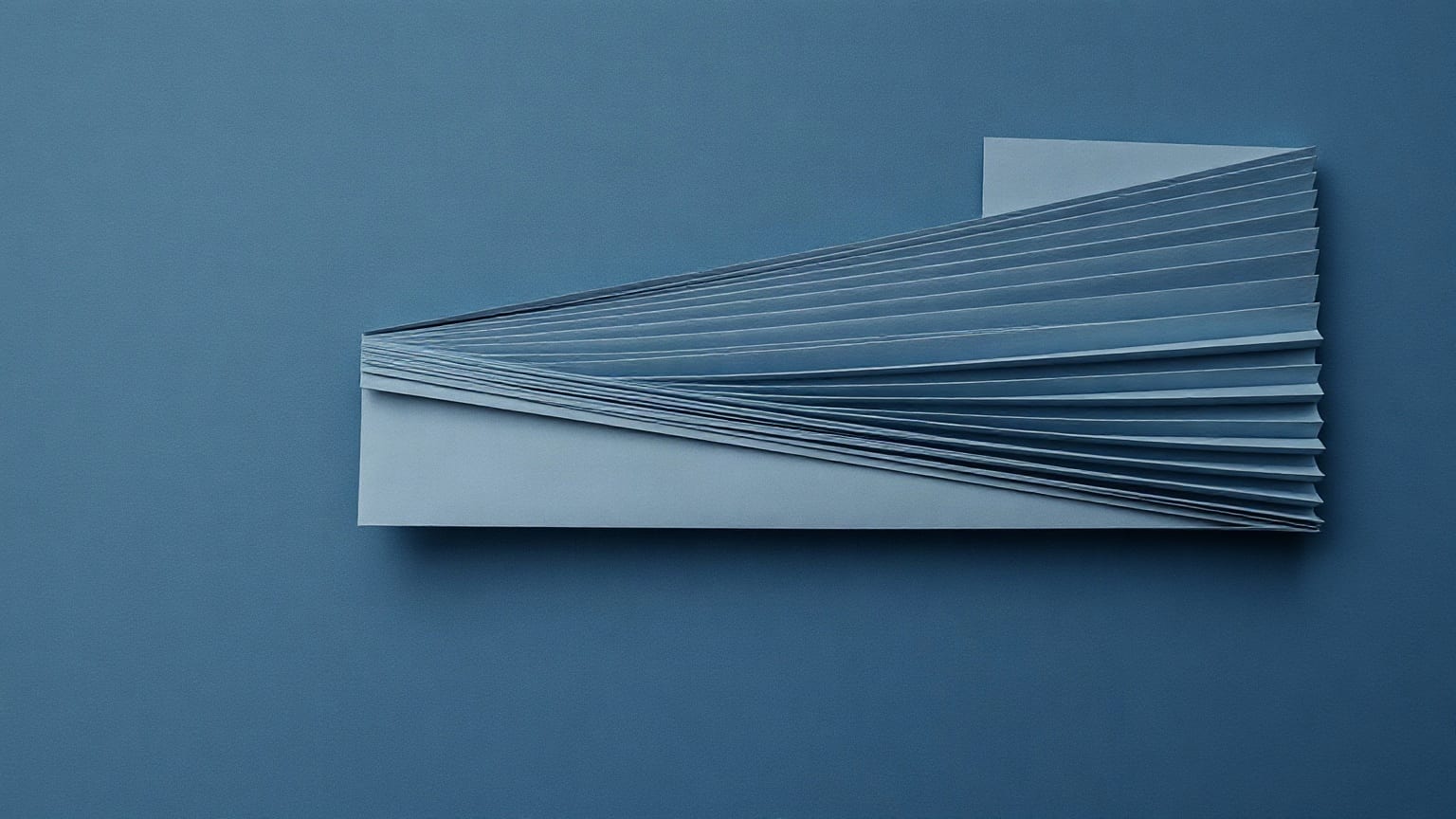 Cut-paper illustration: a long strip of paper fanned into many narrow pleats, lying flat on a blue ground.